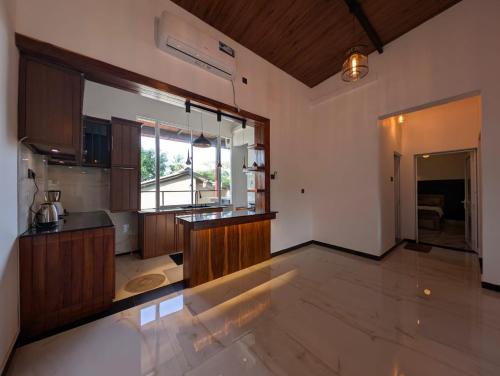 een grote keuken met houten kasten en een groot raam bij Kaveen Homes in Mount Lavinia