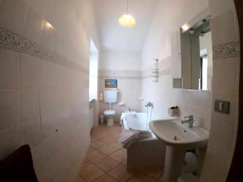 un bagno bianco con lavandino e WC di Agriturismo La Contessa Quarter Horse a Gubbio