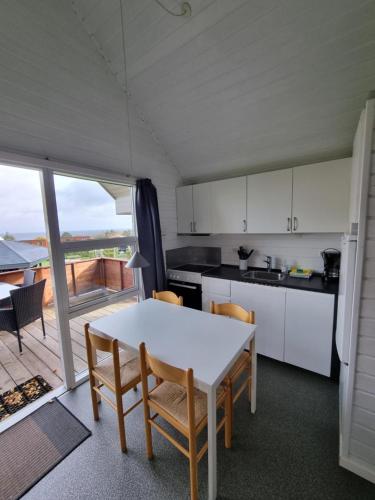 a kitchen and dining room with a table and chairs at Sandkaas Family Camping & Cottages in Allinge