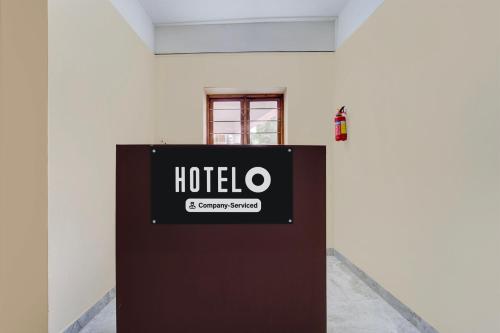 a sign on the side of a white wall at Super Hotel O Kazhakkoottam Near Technopark Phase 3 in Trivandrum