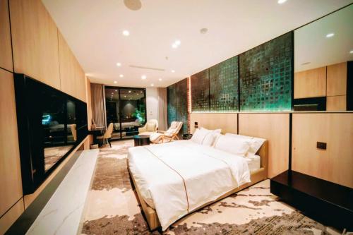 a bedroom with a large bed and a living room at X-Digital HOTEL in Bắc Ninh