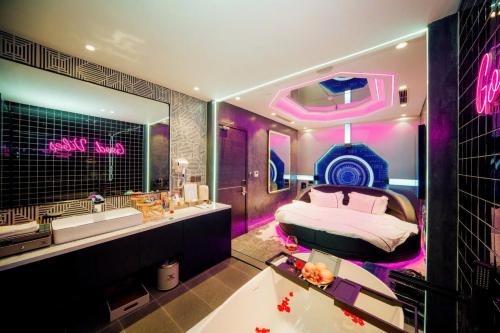 a bedroom with a bed and a sink and a tub at X-Digital HOTEL in Bắc Ninh