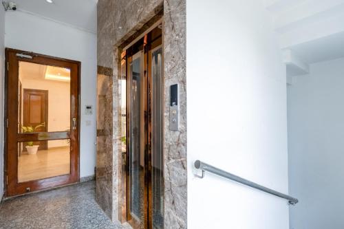 pasillo con puerta y pared de piedra en Hotel Ashiyana Elite I Near Dlf Golf Course Road I Gurgaon, en Gurgaon