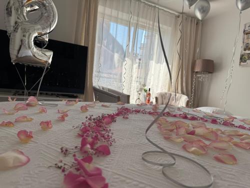 a bunch of pink flowers on a bed at Louis & Elza Old Town Romantic apartments in Wrocław