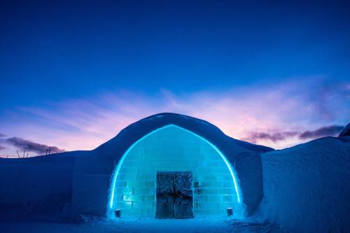 a blue building with a door in the snow at IceHotel in Jukkasjärvi