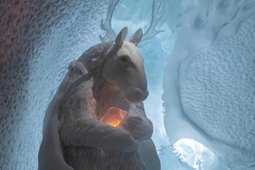 a statue of a reindeer holding a candle at IceHotel in Jukkasjärvi