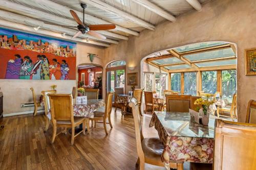 a dining room with a ceiling fan and tables and chairs at Casas de Suenos Old Town Historic Inn, an Ascend Collection Hotel in Albuquerque