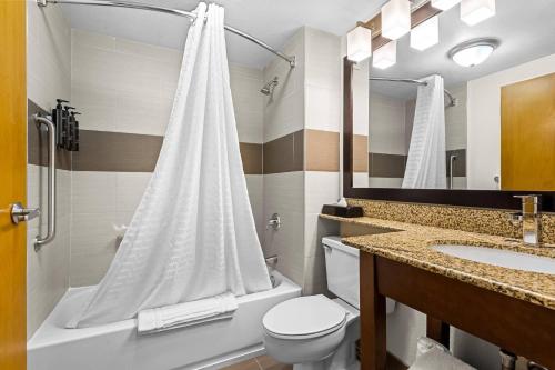 um banheiro com vaso sanitário, pia e chuveiro em Hotel Concord Syracuse, an Ascend Collection Hotel em East Syracuse