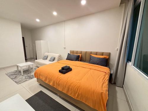 a bedroom with a bed with an orange blanket at Namasstay Silom in Chinatown