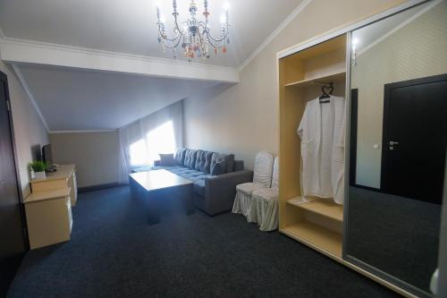 a living room with a couch and a television at Korkem Tau Hotel in Astana