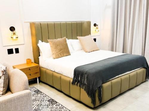 a bedroom with a bed with a large headboard at White House River Manor in Upington