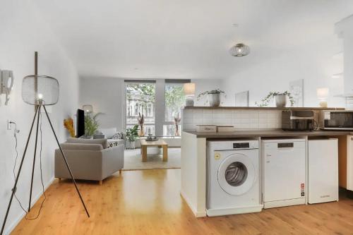 une cuisine blanche avec une machine à laver et un salon dans l'établissement Group-friendly Stay In Tilburg Walk To 013, à Tilbourg