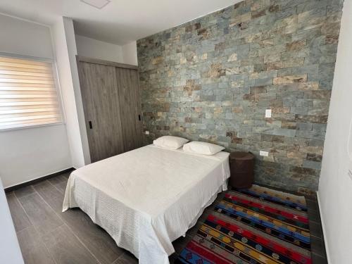 Un dormitorio con una cama y una pared de ladrillo. en Casa de Campo ZEN Descanso Naturaleza, en La Granja