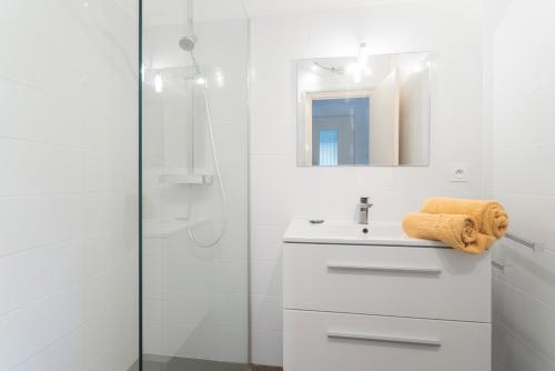 a white bathroom with a sink and a shower at Maison à Argelès in Argelès-sur-Mer