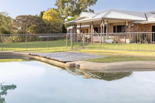 a pool of water in front of a house at Coastview Manor - Family Hinterland Retreat in Valdora