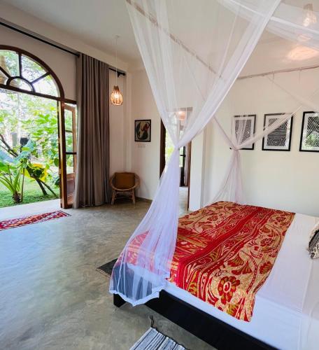 a bedroom with a bed with a mosquito net at La Sirena Villa in Talpe