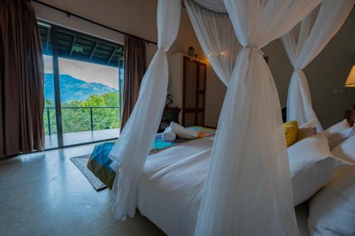 a bedroom with a bed and a large window at Ella Nine Peaks in Ella