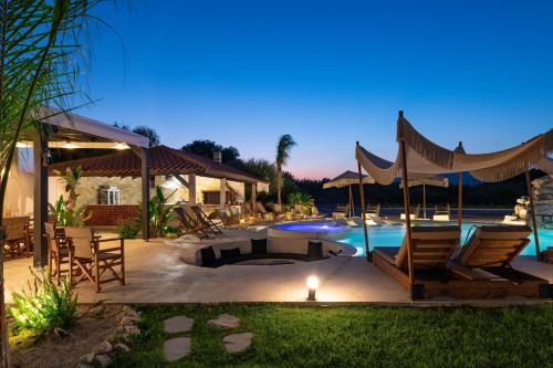 a backyard with a pool and chairs and a house at Vento Estivo Mansion in Pastida