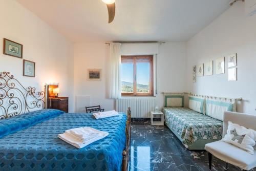 a bedroom with two beds and a window at Agriturismo Osea in Monteriggioni