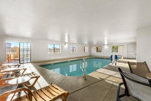 a swimming pool with tables and chairs in a building at Comfort Inn & Suites Surprise Near Sun City West in Surprise