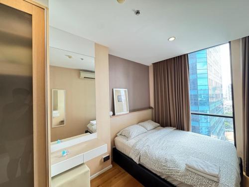 Ένα ή περισσότερα κρεβάτια σε δωμάτιο στο Ekkamai Bangkok Condo