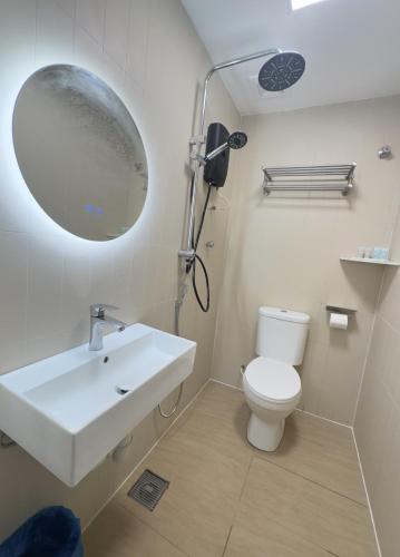 a bathroom with a white sink and a toilet at Blenz Hotel in Serdang