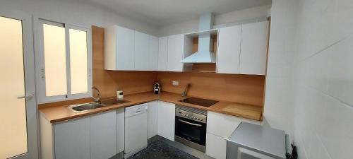 een kleine keuken met witte kasten en een spoelbak bij Mar 4 en Santa Pola in Santa Pola