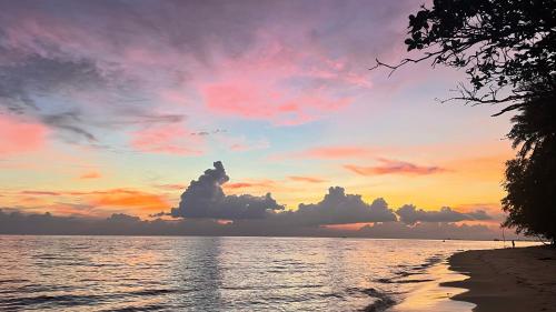 a sunset on the beach with clouds in the sky at A Day Rayong in Ban Pa Khan