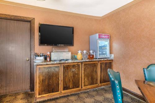 a room with a television on a wooden cabinet at The Inn at Gran View Ogdensburg, an Ascend Collection Hotel in Ogdensburg