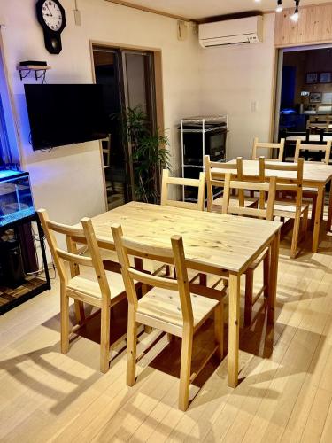 a wooden table and chairs in a room at 小さなペンション Branchee in Kushimoto