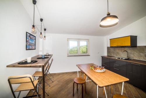 a kitchen with a table and some chairs and a table at Le Voyageur Cilento in Vibonati