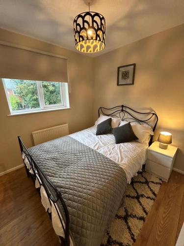a bedroom with a bed and a chandelier at Cosy Family Home in Lovely Stony Stratford in Stony Stratford
