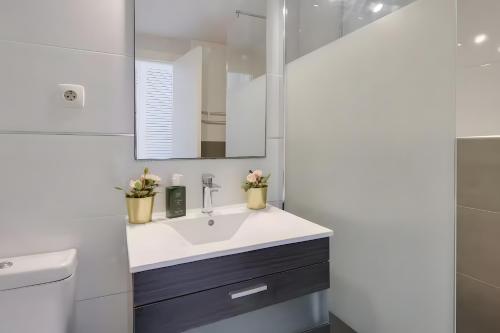 ein Badezimmer mit Waschbecken, Toilette und Spiegel in der Unterkunft Siesta style in Port d'Alcúdia