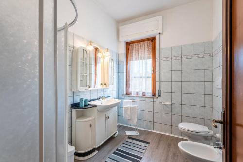 a white bathroom with a sink and a toilet at Agriturismo Osea in Monteriggioni