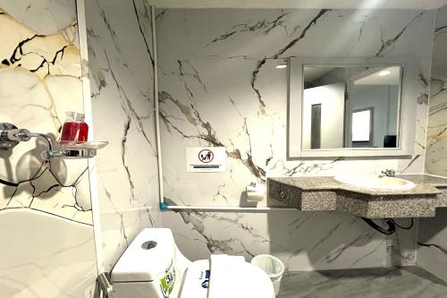 a bathroom with a sink and a toilet and a mirror at Jomtien Wave Residence in Jomtien Beach