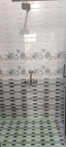 a bathroom with aaucet and a tile wall at hotel pink city in Rīngas