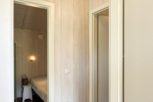 a door to a bedroom with a bed and a mirror at Schatzkiste - Dorf Ferienhaus 4a in Priwall