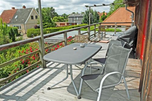 a table and chairs on a deck with flowers at Ferienwohnung mit Dachterrasse Kamin nahe dem Strelasund in Franken Vorstadt