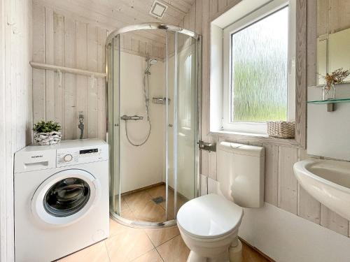 a bathroom with a washing machine and a toilet at Schatzkiste - Dorf Ferienhaus 08 in Priwall