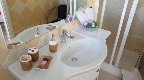 ein Badezimmer mit einem Waschbecken, einem Spiegel und einem Waschbecken in der Unterkunft Villa Panorama sulle Egadi in Parrinello 