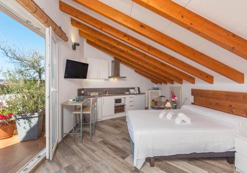 Un dormitorio grande con una cama y una cocina. en Apartamentos Al Andalusí, en Denia