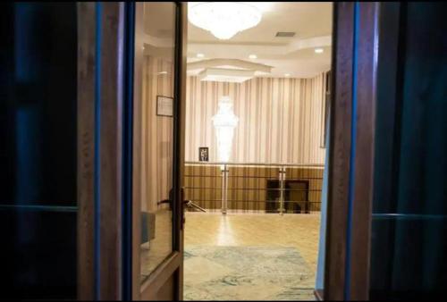 una puerta de cristal que da a una habitación con una habitación grande en Sebail inn shah hotel and Shah hostel, en Baku
