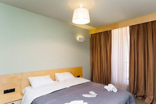 a hotel room with a bed with two slippers on it at 1BR apart 1 min from M Kokhta 3rd floor in Bakuriani