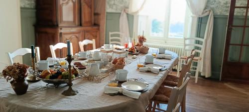 un lungo tavolo con del cibo sopra in una sala da pranzo di Le Manoir du Châtelier a Bressuire