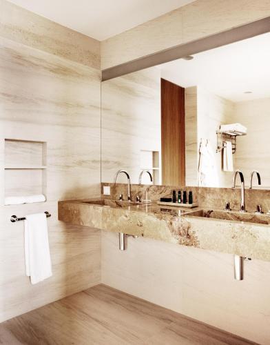 a bathroom with two sinks and a mirror at Square Nine Hotel Belgrade, Member of The Leading Hotels of the World in Belgrade
