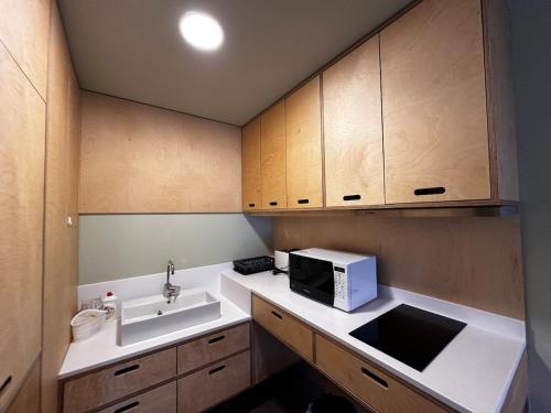a small kitchen with a sink and a microwave at The 4th Floor Vista in front of Kokhta in Bakuriani