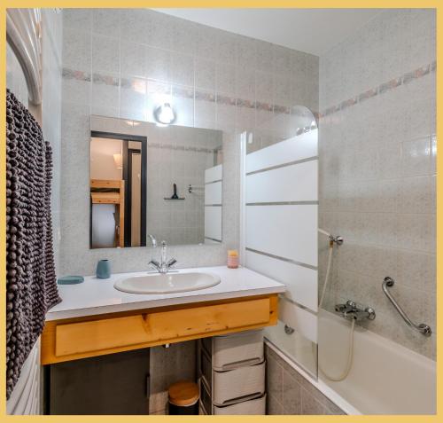 a bathroom with a sink and a mirror and a tub at Le Paradisio I Studio I Morzine in Morzine
