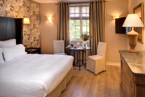 a hotel room with a bed and a table at CAZAUDEHORE Hôtel Restaurant Gastronomique Terrasse et Jardins in Saint-Germain-en-Laye