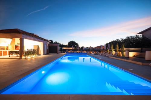 a large blue swimming pool in a backyard at Villa Lucy Apartments in Vir