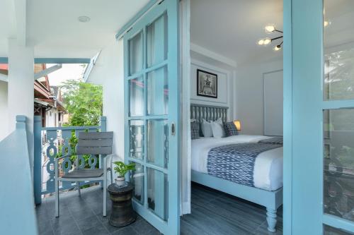a bedroom with a bed and a balcony at Luangprabang D'or Boutique Hotel in Luang Prabang